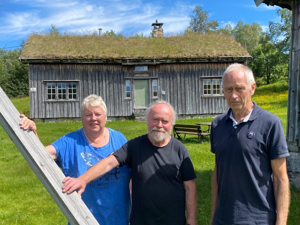 Fra venstre: Torbjørg Haugen, Odd Kvinen og Magnar Undheim ønsker å ta vare på kulturarven. Hovedhuset, Jørenhuset, ses i bakgrunnen.